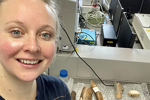 Dr Rebecca Shepherd with mammoth ivory samples obtained from the Natural History Museum. In the background, the benchtop Raman spectrometer is shown
